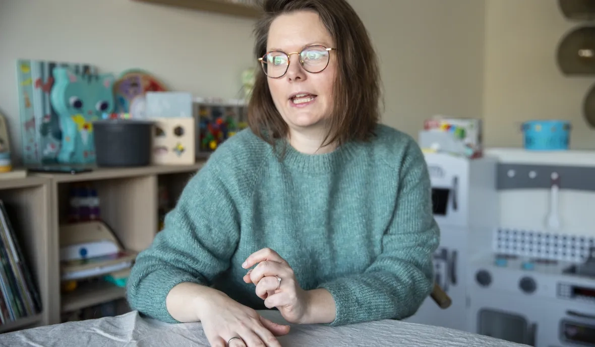 Ann Helen sitter ved et bord og snakker