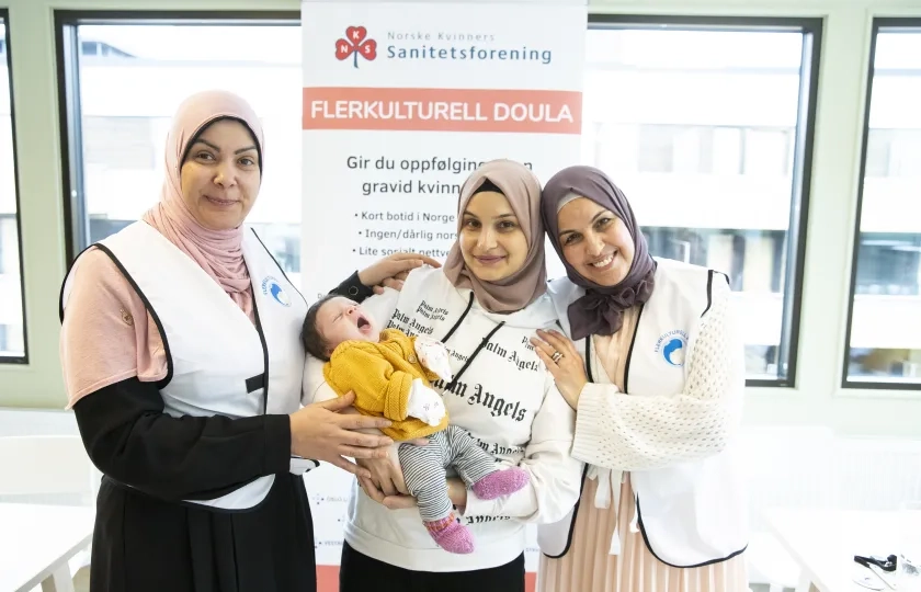 to flerkulturelle doula sammen med nybakt mor og baby