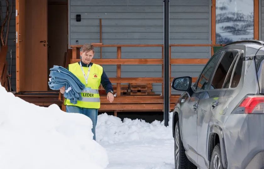 Frivillig Sanitetskvinne deler ut tepper under stengte veier pga sn&oslash;skred